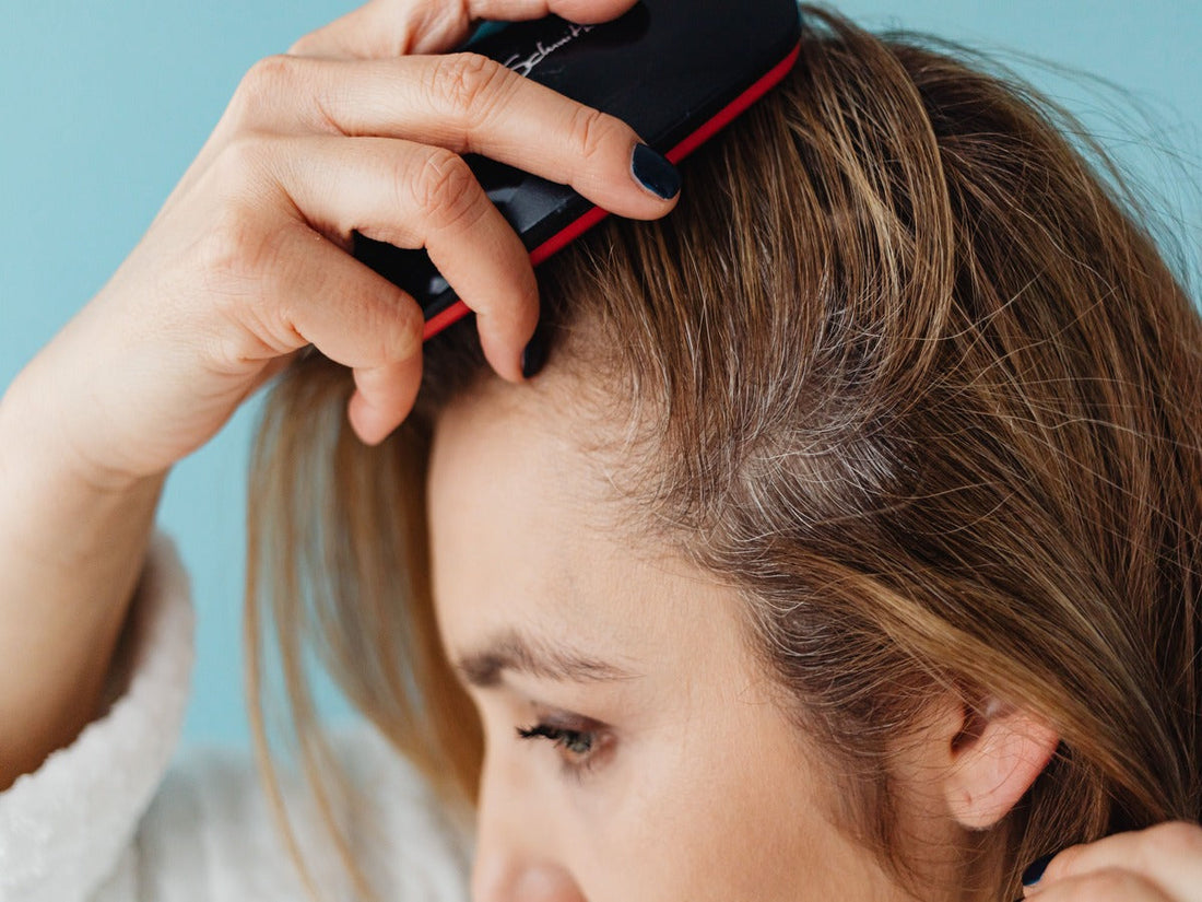 A lady brushing her oily scalp.
